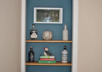 Shelves with old bottles and a pile of books.