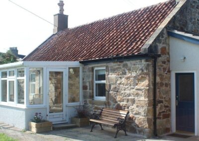 Sunroom and an angle-roofed extension have doors into the property.