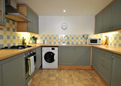 Kitchen shows an oven, washing machine and microwave oven.