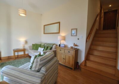 Wooden sideboard between the sofa and armchair.