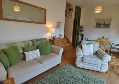 Dining area is situated behind the lounge, at the foot of the wooden staircase.