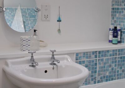 White sink with small aqua and white tiles.