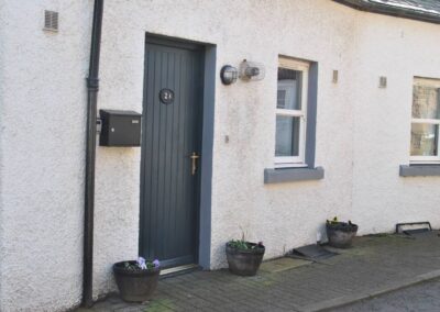 View of the dark green/blue front door which is wooden with 2A on the door, surrounded by white pebbledash.