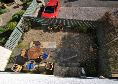 Aerial view of patio area with allocated parking space beyond the garden fence.