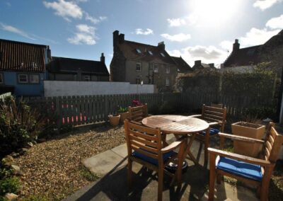 View across patio table towards a blue sky with white clouds.