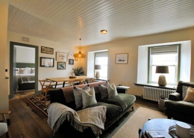 Lounge with green sofa and wooden table.