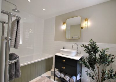 Bathroom in neutral colours. There is a shower over the bath.