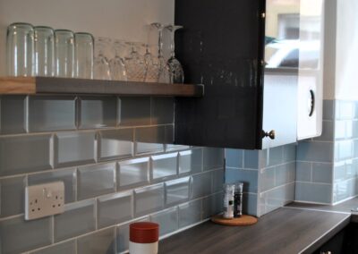 Close up of glasses shelf in kitchen.