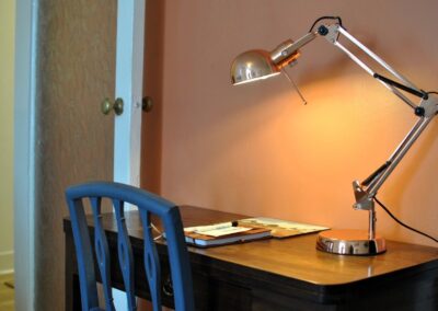 Desk with chair and angle-poise lamp.