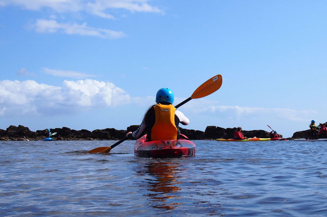 Young person in a canoe on the water.