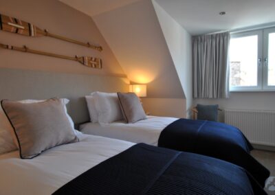 View across two single beds towards a wide windo built into the roof.