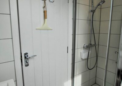 Walk-in shower in tiled room.